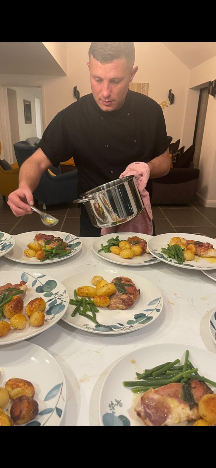 Chef plating saltimbocca with green beans for a private dinner