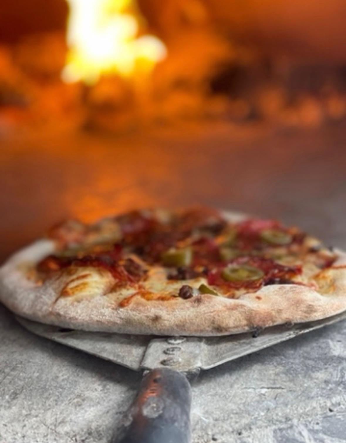 Wood-fired salami pizza fresh from the oven