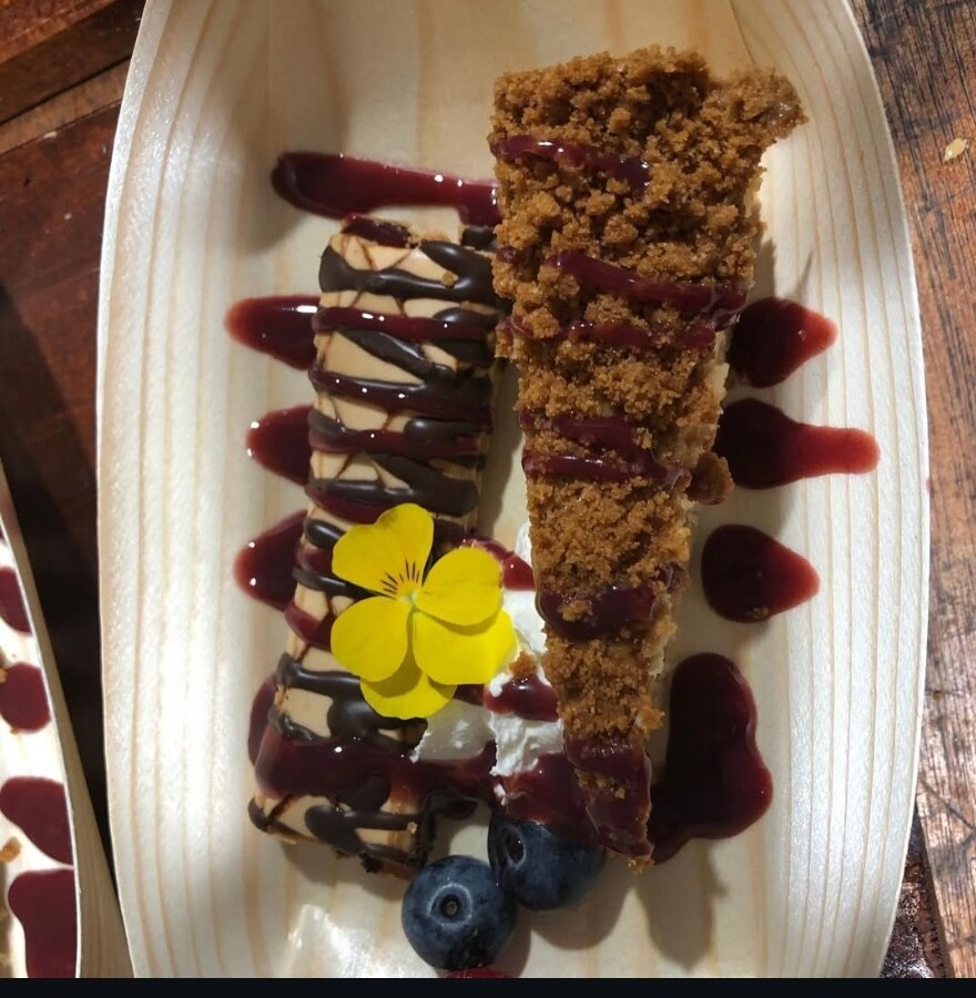 Saluté dessert — cheesecake and crumble with berry coulis and edible flower