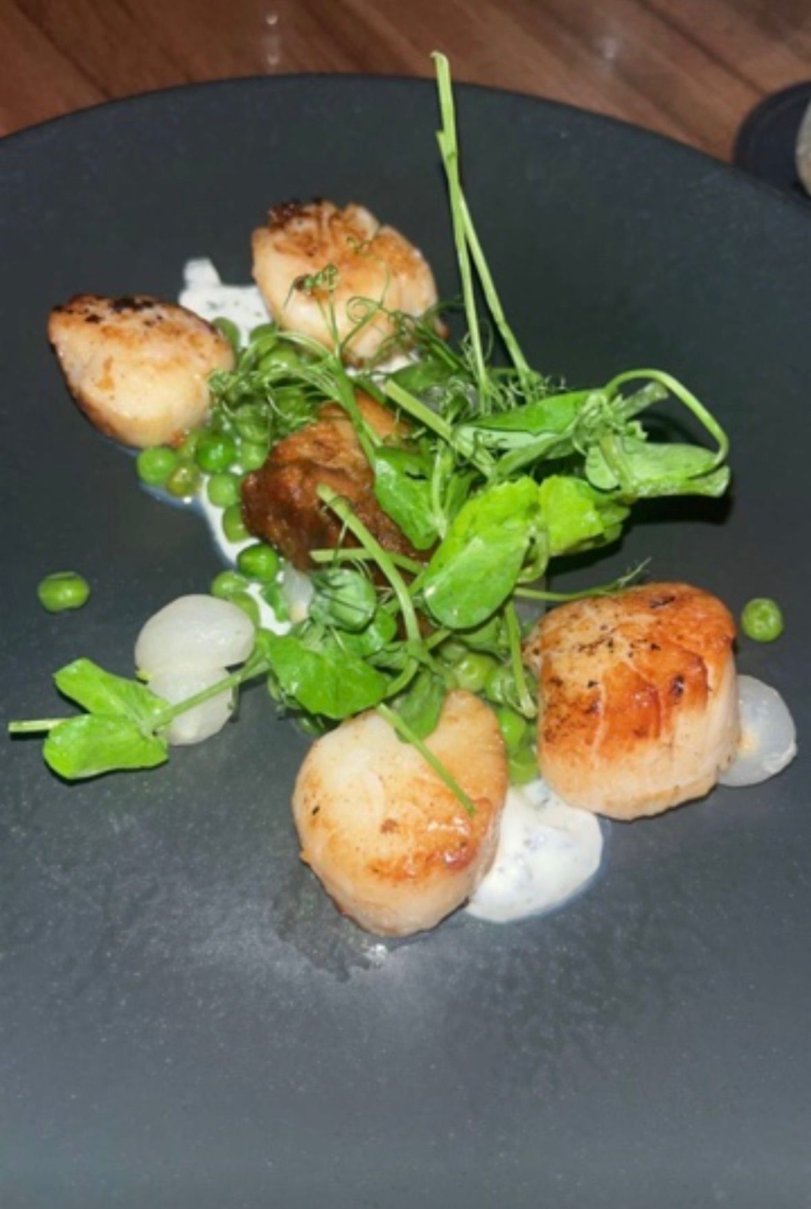 Seared scallops with peas and pea shoots